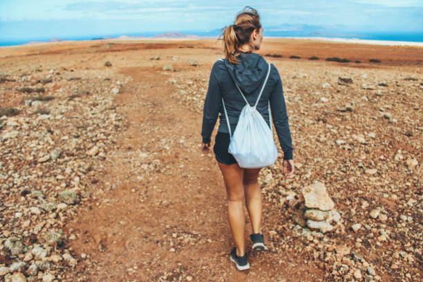 istock Young woman hiking with panoramic view on volcano 886167972