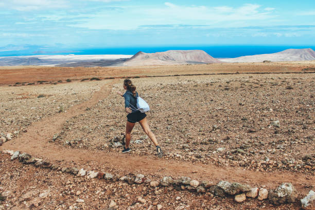 istock Young woman running on volcano 886168256