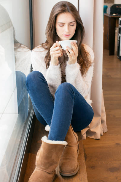 istock Beautiful Woman With Coffee by the window 886172640