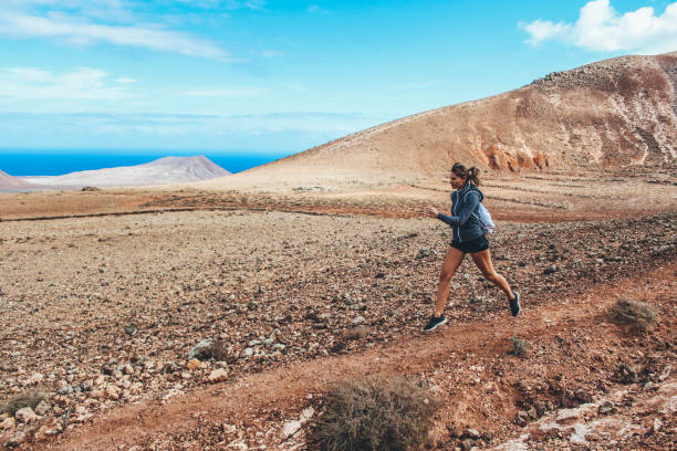 istock Young woman running on volcano 886173028