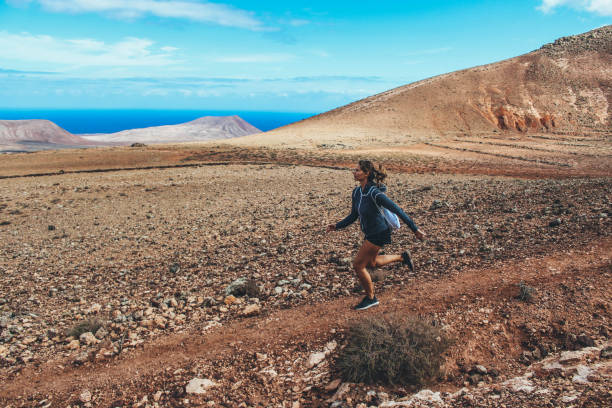 istock Young woman running on volcano 886173386