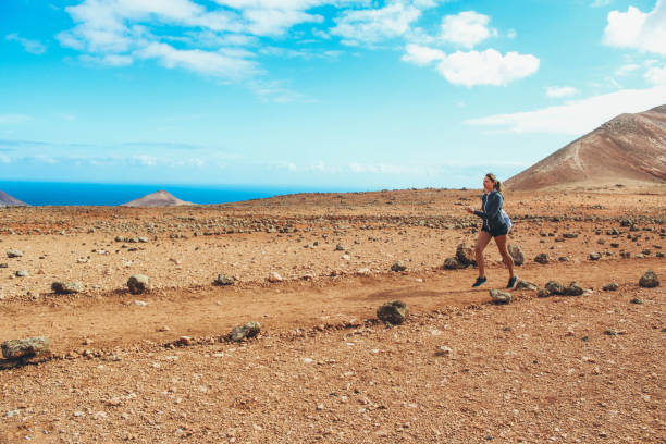 istock Young woman running on volcano 886175822