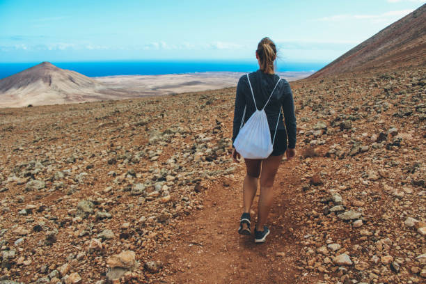 istock Young woman hiking with panoramic view on volcano 886176246