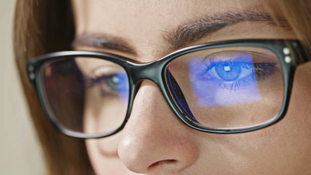 Woman Eyes with Glasses Close-up shot of woman eyes in glasses reflecting a working computer blue screen alternative pose photos stock pictures, royalty-free photos & images