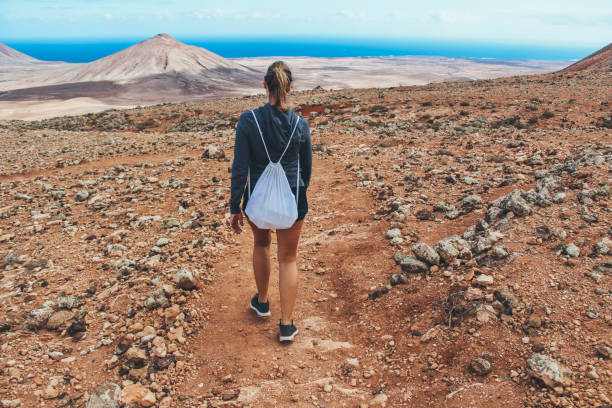 istock Young woman hiking with panoramic view on volcano 886176580