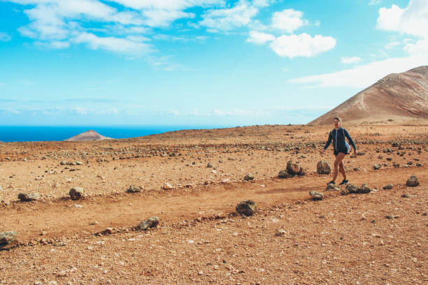 istock Young woman hiking with panoramic view on volcano 886179100