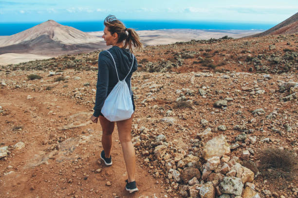 istock Young woman hiking with panoramic view on volcano 886179300