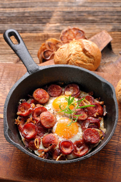 istock Fried eggs with sausage and onion on frying pan 886183058