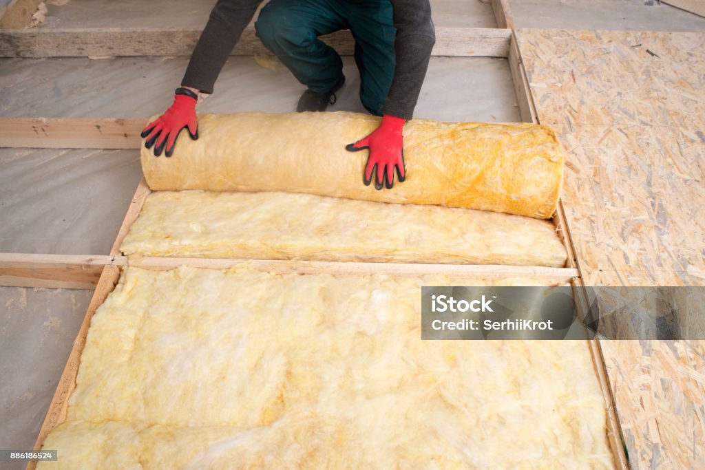 worker insulates the floor with mineral wool Insulation Stock Photo