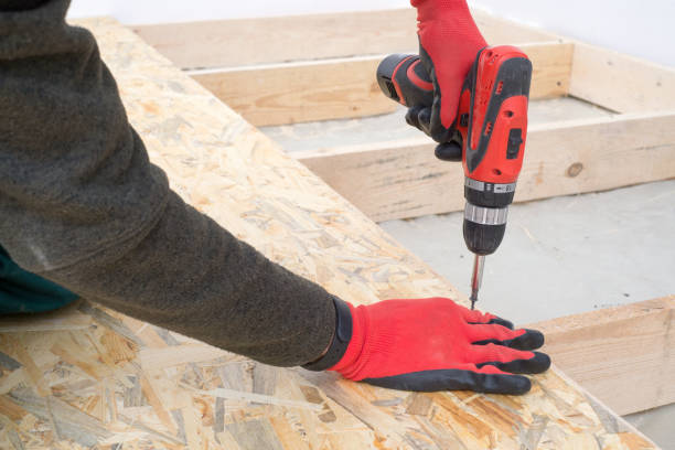 człowiek śruby pracownika drewniane zorientowane stoi bords na izolowane podłogi. nowy dom constuction - drill red work tool power zdjęcia i obrazy z banku zdjęć