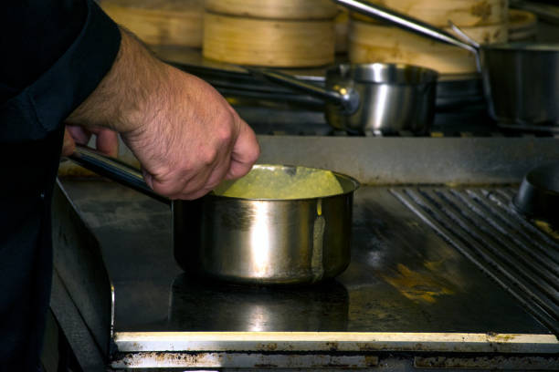 istock Chef in restaurant kitchen at stove with pan 886193588