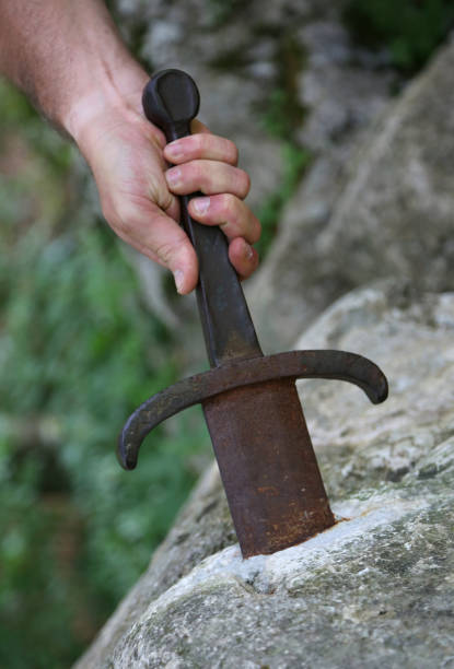 istock hand trying to draw the sword into the rock 886194156