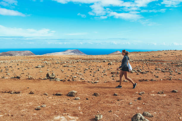 istock Young woman hiking with panoramic view on volcano 886205210