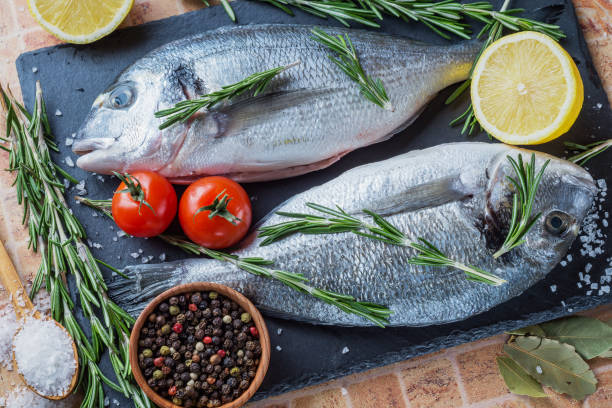 istock Fresh fish Dorado with lemon, rosemary and spices. 886205318