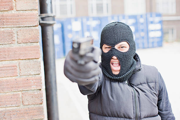 homem em pele máscara segurando arma - aggression control clothing image type - fotografias e filmes do acervo