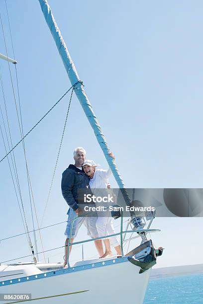 Coppia Matura Abbracciare Sul Ponte Della Barca A Vela - Fotografie stock e altre immagini di Barca a vela