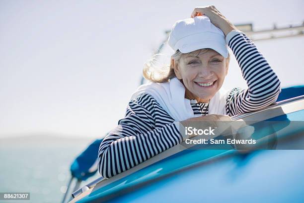 Mujer Sentada En La Terraza De Barco Foto de stock y más banco de imágenes de 55-59 años - 55-59 años, Actividad de fin de semana, Adulto