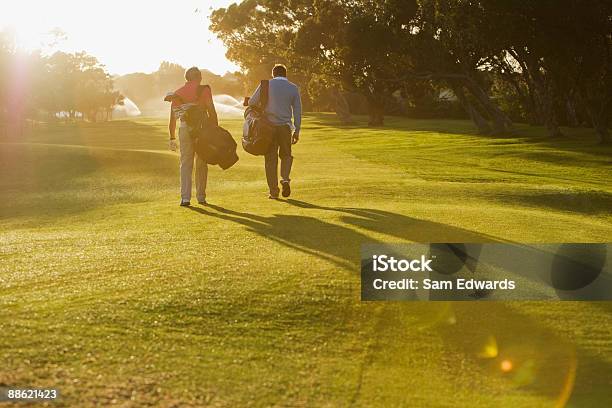 Photo libre de droit de Homme Porter Les Sacs De Golf Sur Le Parcours De Golf banque d'images et plus d'images libres de droit de Golf