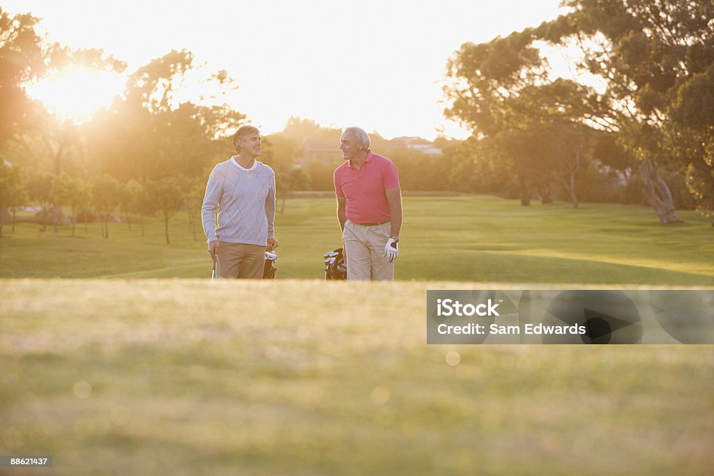 Men pulling golf carts on golf course  Golf Stock Photo