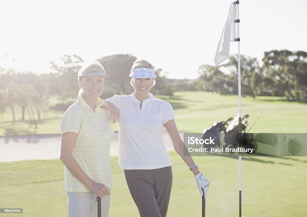 Друзья, которые позируют на поле для гольфа - Стоковые фото Женщины роялти-фри