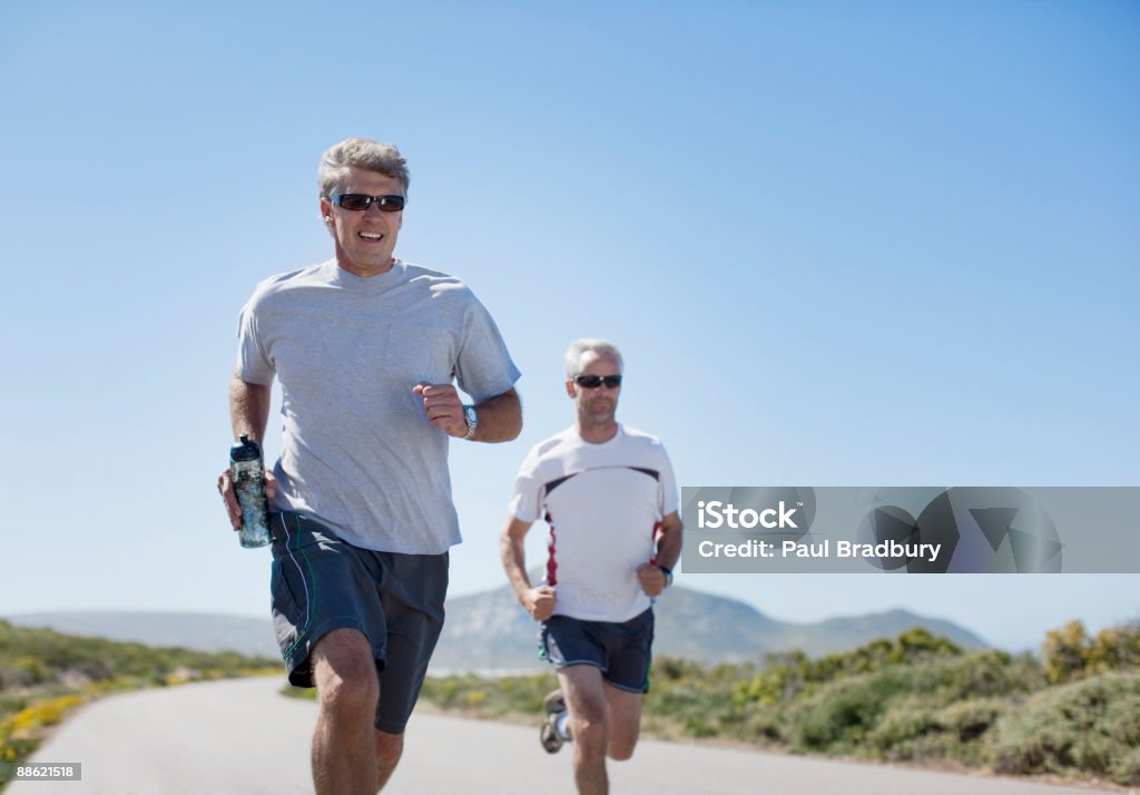 Men jogging and carrying water bottles  Blue Stock Photo