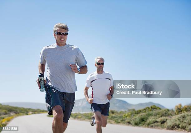 Men Jogging And Carrying Water Bottles Stock Photo - Download Image Now - Blue, Jogging, Motion