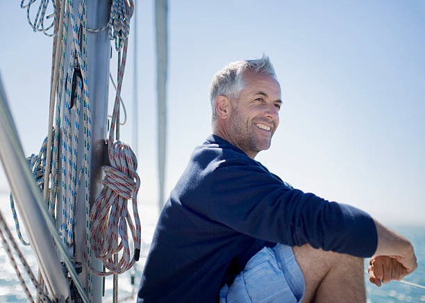 Man sitting on deck of boat  45 49 years photos stock pictures, royalty-free photos & images