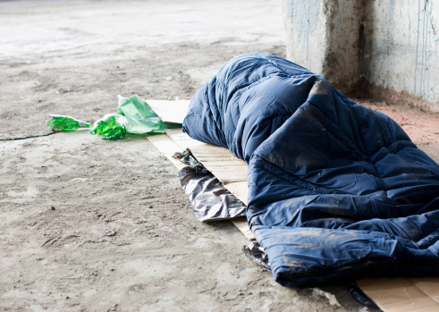 Homeless hombre durmiendo en saco de dormir en cartón photo