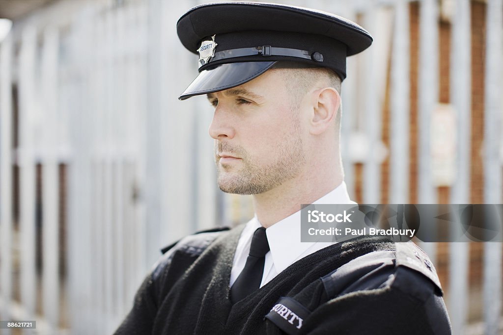 Agent de sécurité debout près de clôture - Photo de Agent de sécurité libre de droits