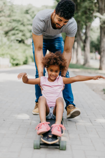 istock Father and daughter in park skateboarding 886232918