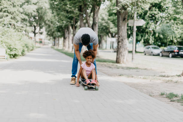 istock Father and daughter playing with penny board at the park 886232986