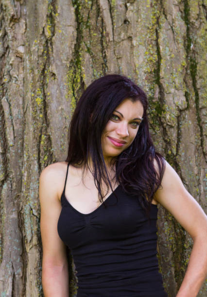 istock Young Woman Standing By A Large Tree In A Park 886240156