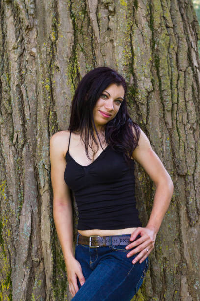 istock Young Woman Standing By A Large Tree In A Park 886240176