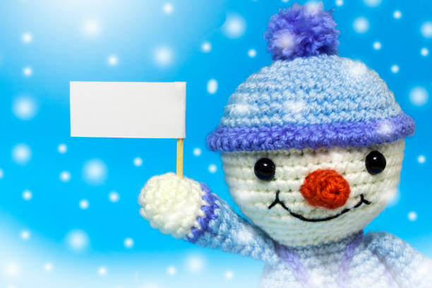 istock with the right snowman with posters on a blue background, it's snowing 886258134