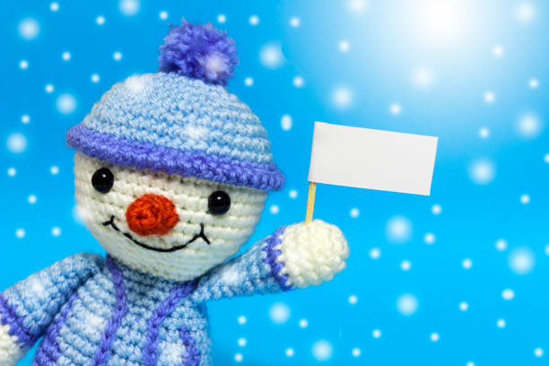 istock snowman with posters on a blue background, with exposure, it's snowing 886258142