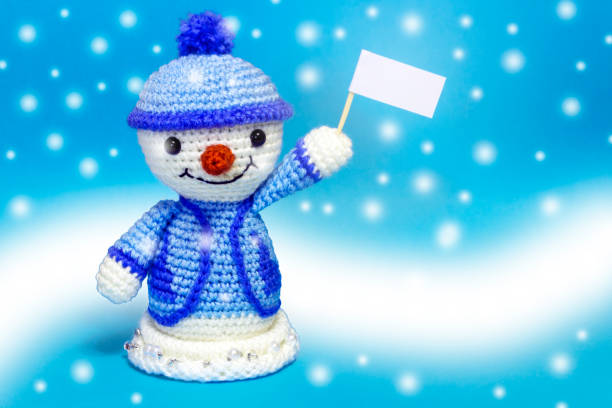 istock one snowman with posters on a blue background, it's snowing 886258186