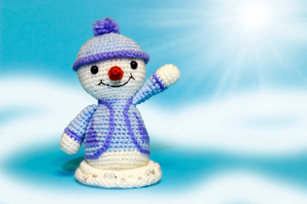 istock a snowman waves his hand against a blue background 886258220