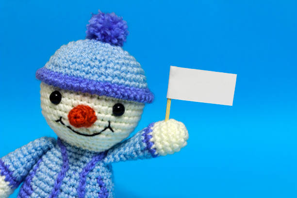 istock one with a snowman left with posters on a blue background, close up 886258266