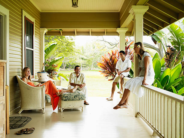 group of friends sitting on front porch laughing - lahaina ストックフォトと画像