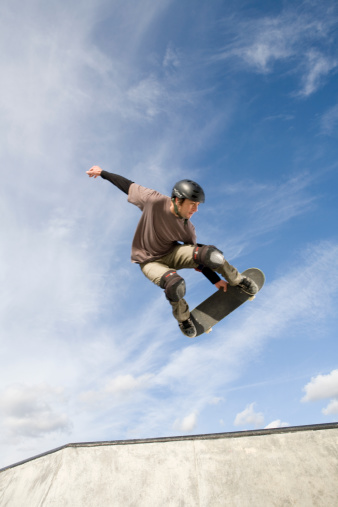 A male skateboarder catches some air out of the bowl.