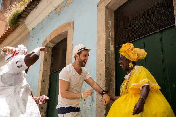 turista che balla con la donna brasiliana locale "baiana" a pelourinho, salvador, bahia, brasile - samba (brasile) foto e immagini stock