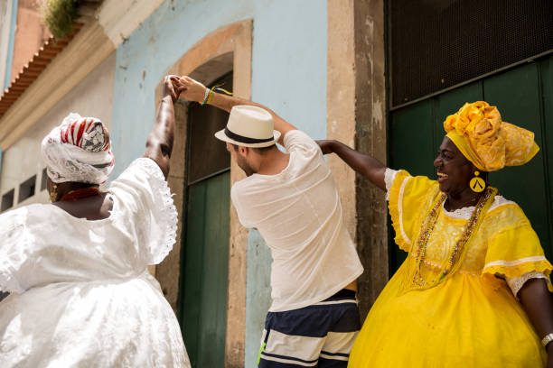 turista che balla con la donna brasiliana locale "baiana" a pelourinho, salvador, bahia, brasile - samba dancing foto e immagini stock