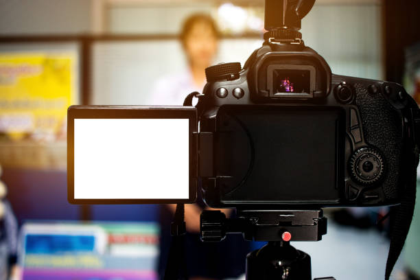 istock Woman on set Video camera, camcorder interviews, operator working for record speaker or Presenter in office, blak white screen. Interview is conversation where questions are asked and answers given 886280836