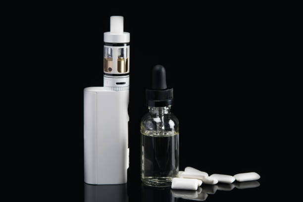 istock electronic cigarette with dressing for her, flavor of chewing gum on a black background, with a hatching 886294708
