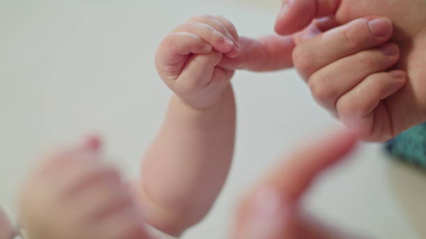 istock Mother's Finger is Holding Baby's Fist 886308314