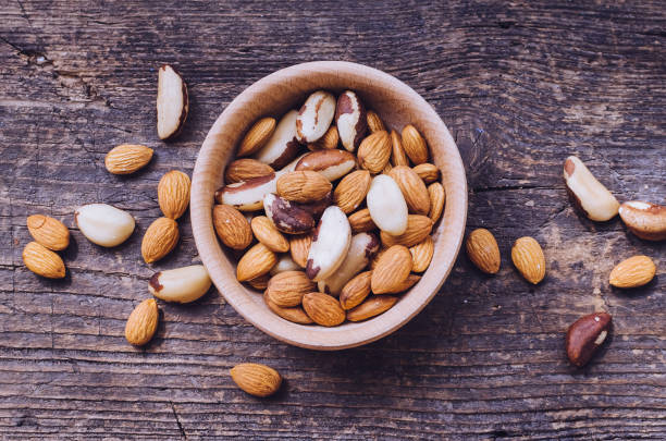 istock Nuts mix in wooden bowl 886308458