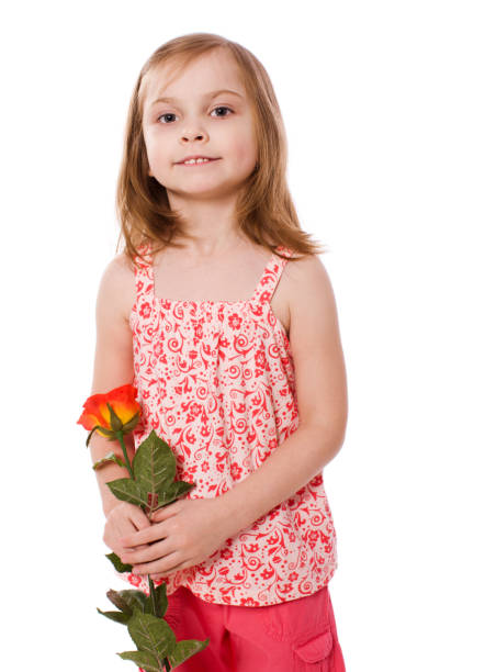 a boy with vitiligo in a red T-shirt with a bouquet of mimosa on a black studio background