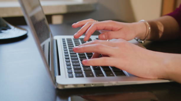 istock Female Hands Typing Text on Laptop Keyboard 886322100