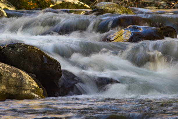 многоуровневый водопад в горной реке с желтыми отражениями осенних листьев - north carolina mountain river autumn стоковые фото и изображения