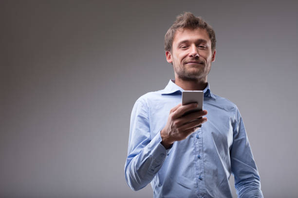 istock Young man reading a text message on his cellphone 886354648